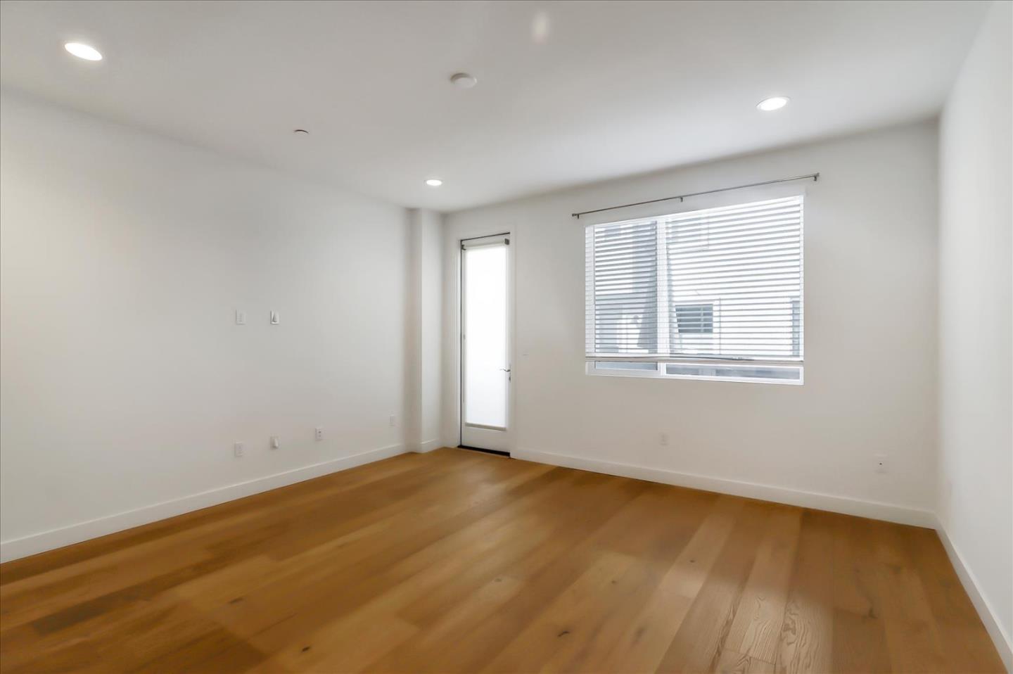 152 Uptown Circle Oakland, CA 94607 - Photo 9 of 33 a view of an empty room with wooden floor and a window