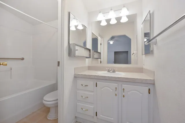 a bathroom with a sink a toilet and a large mirror