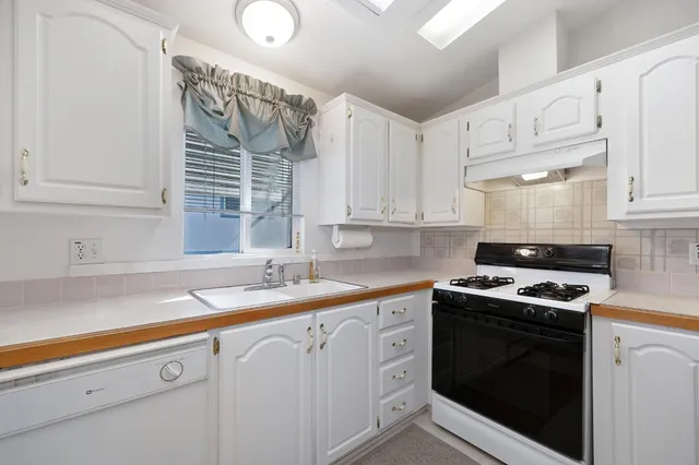 a kitchen with white cabinets and white appliances