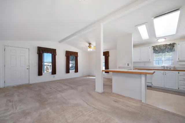 a large white kitchen with granite countertop a sink white cabinets and a granite counter tops