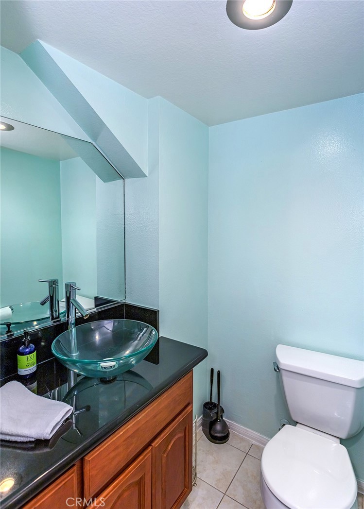 7065 9th Street, Unit 1 Buena Park, CA 90621 - Photo 13 of 36 a bathroom with a granite countertop toilet and a sink