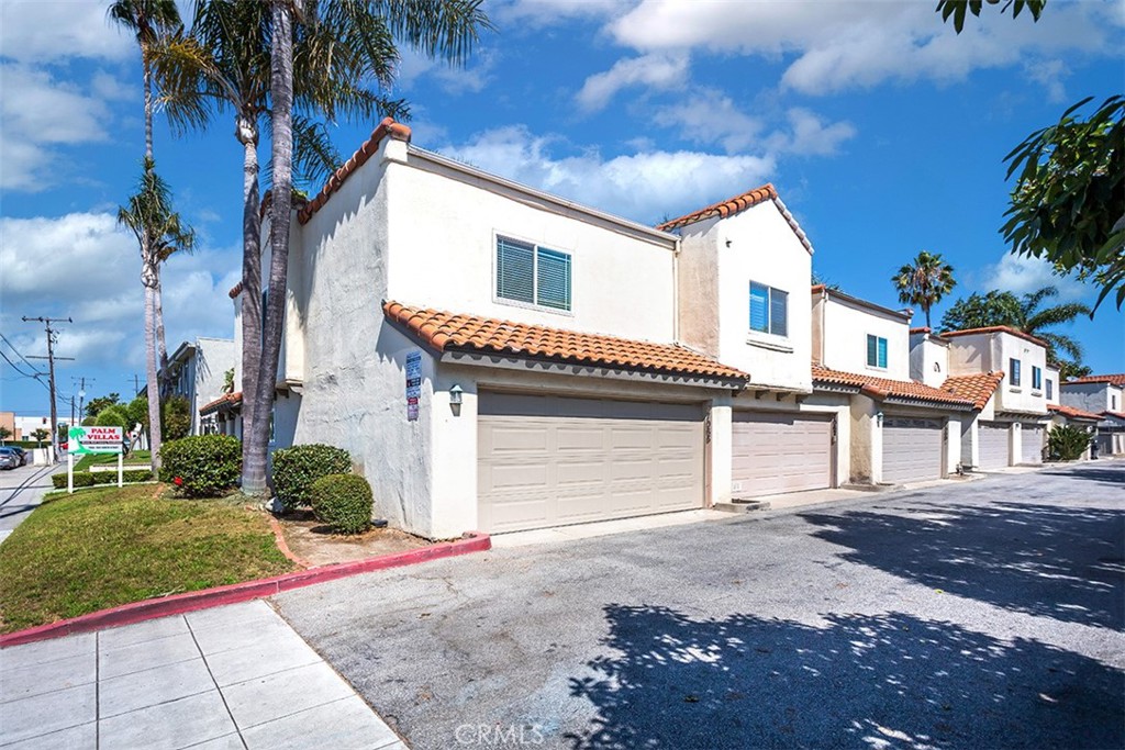 7065 9th Street, Unit 1 Buena Park, CA 90621 - Photo 2 of 36 a front view of a house with a yard and garage