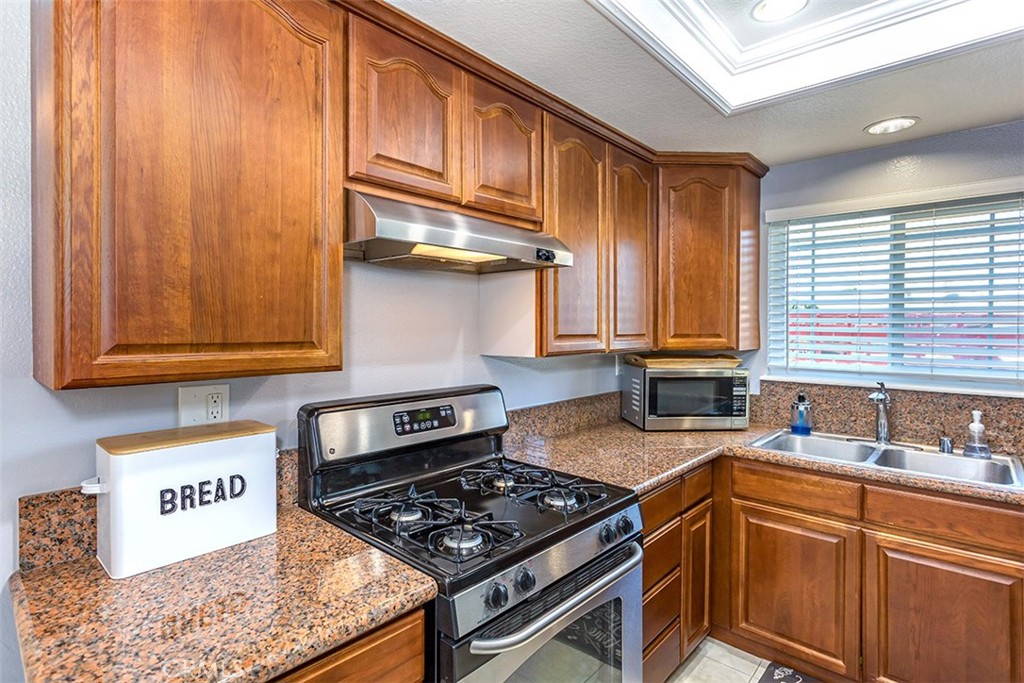 7065 9th Street, Unit 1 Buena Park, CA 90621 - Photo 8 of 36 a kitchen with stainless steel appliances granite countertop a stove a sink and a microwave