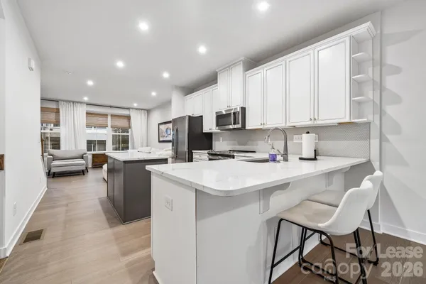 a kitchen with a sink a stove a refrigerator cabinets and dining table