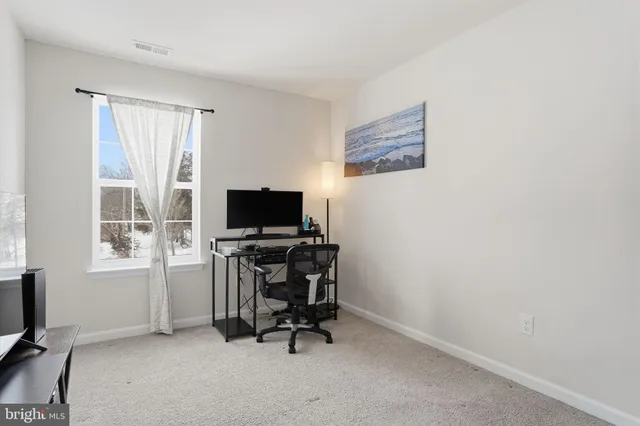 a view of a livingroom with workspace and a window