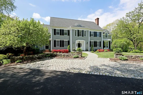 a view of a white house with a yard and sitting area