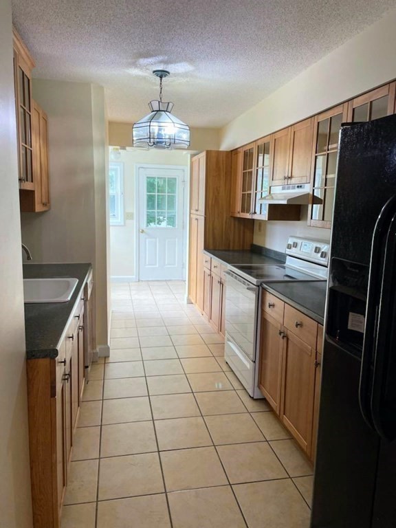 81 Mitchell Drive, Unit 81 Chicopee, MA 01022 - Photo 4 of 18 a kitchen with stainless steel appliances granite countertop a refrigerator a sink dishwasher a stove with wooden cabinets