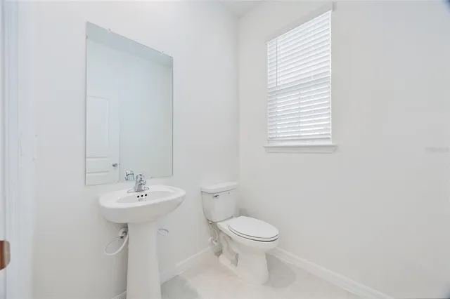a bathroom with a sink toilet and a mirror