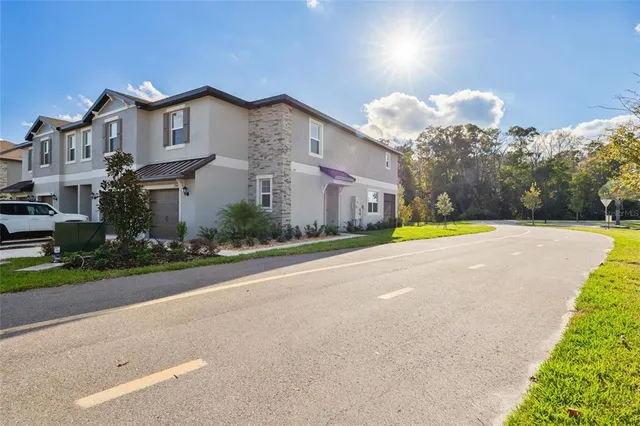 a view of a house with a yard and a large tree