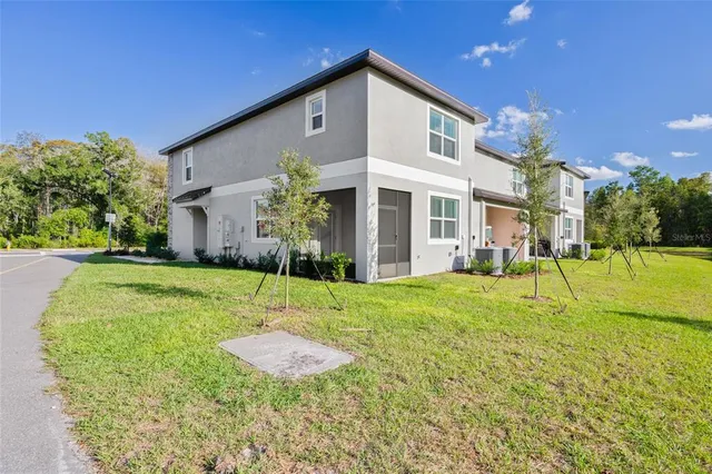 a view of a house with backyard and a patio