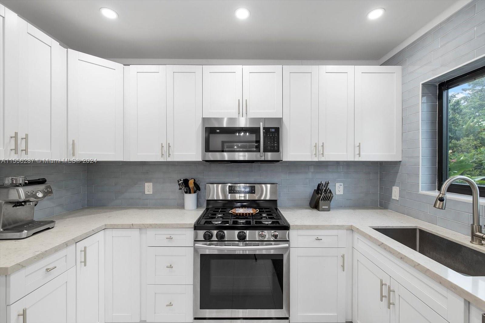 4631 Southwest 12th Street Miami, FL 33134 - Photo 14 of 28 a kitchen with granite countertop white cabinets and white appliances