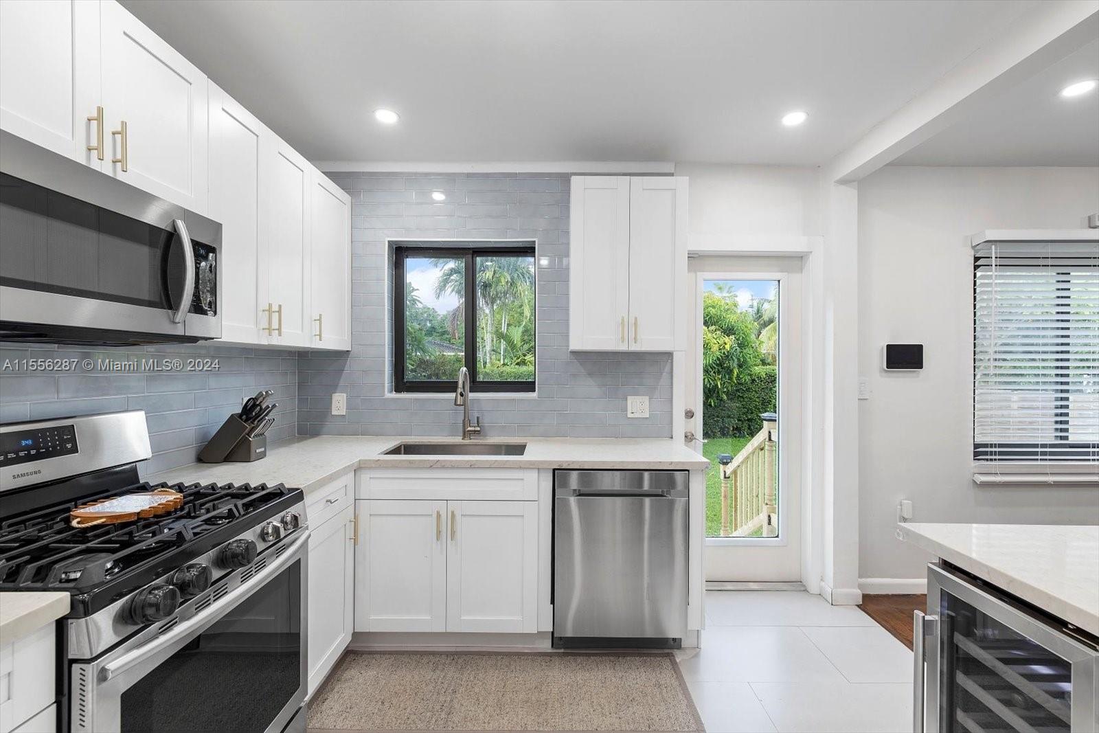 4631 Southwest 12th Street Miami, FL 33134 - Photo 16 of 28 a kitchen with a stove a sink and a microwave