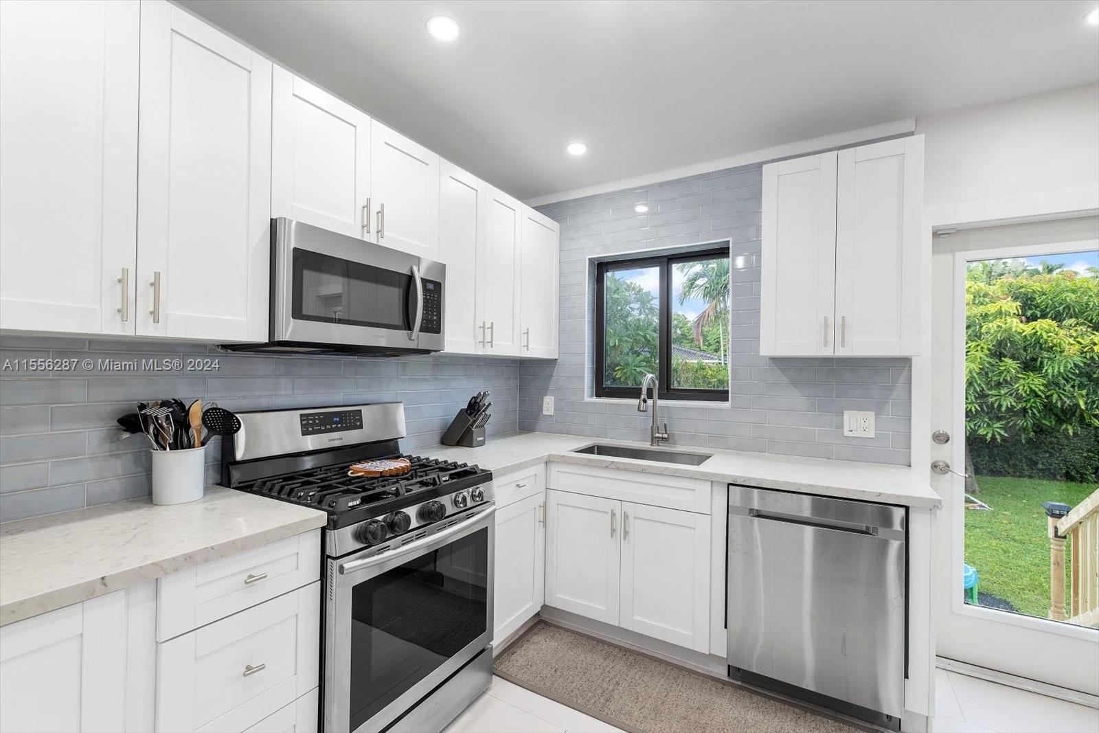 4631 Southwest 12th Street Miami, FL 33134 - Photo 17 of 28 a kitchen with white cabinets appliances and a window