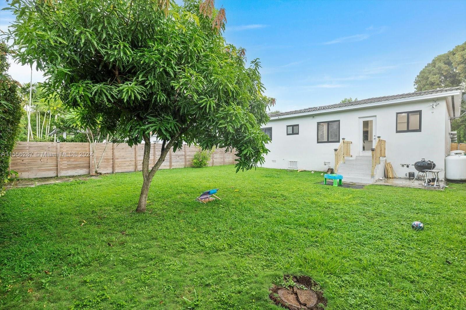 4631 Southwest 12th Street Miami, FL 33134 - Photo 22 of 28 a backyard of a house with table and chairs