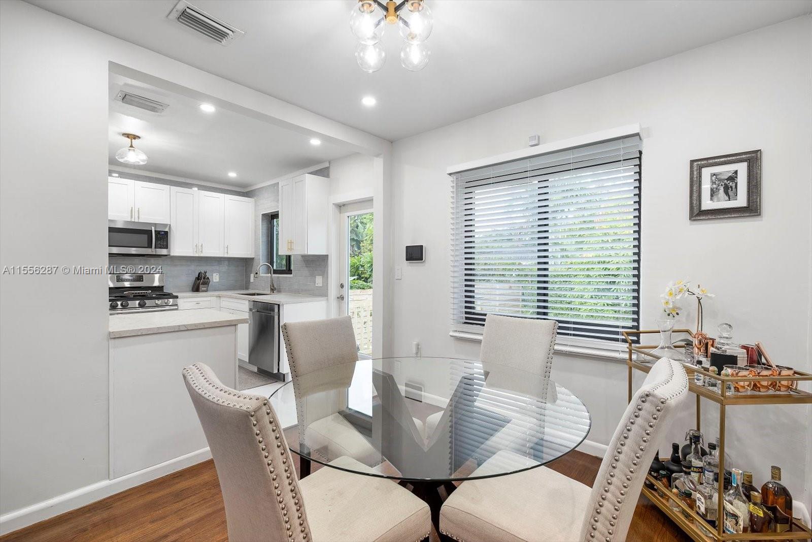 4631 Southwest 12th Street Miami, FL 33134 - Photo 9 of 28 a view of a dining room with furniture and wooden floor