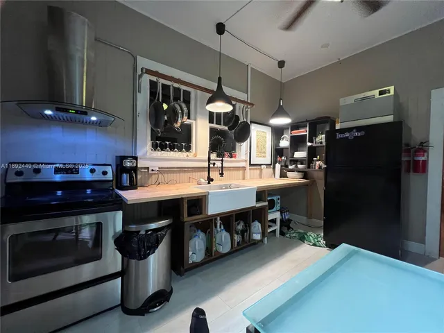 a kitchen with stainless steel appliances granite countertop a stove a sink dishwasher and a refrigerator with wooden floor