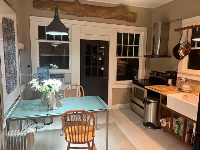a kitchen with a stove and a dining table with chairs