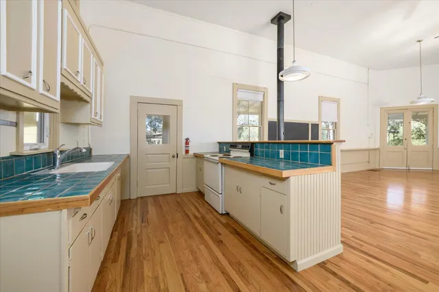 a kitchen with granite countertop white cabinets and white appliances