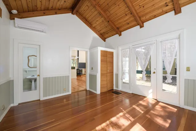 a view of an entryway with wooden floor and a livingroom