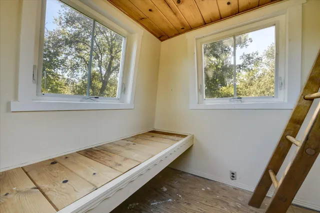 a view of a room with wooden floor and a window