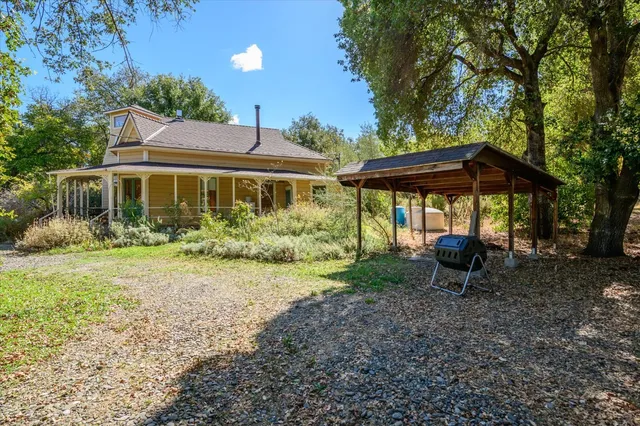 a view of a house with backyard and sitting area