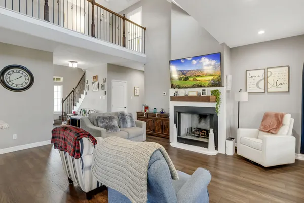 a living room with furniture a flat screen tv and a fireplace