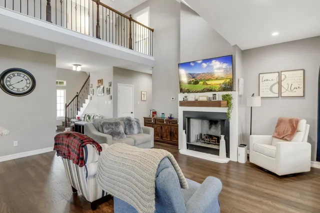a living room with furniture a flat screen tv and a fireplace