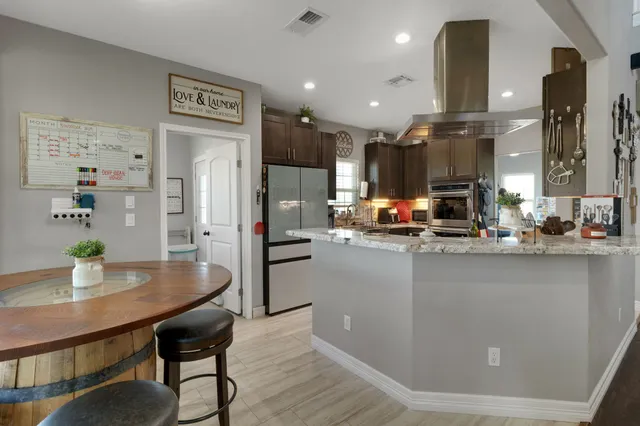 a kitchen with stainless steel appliances a dining table chairs and stove