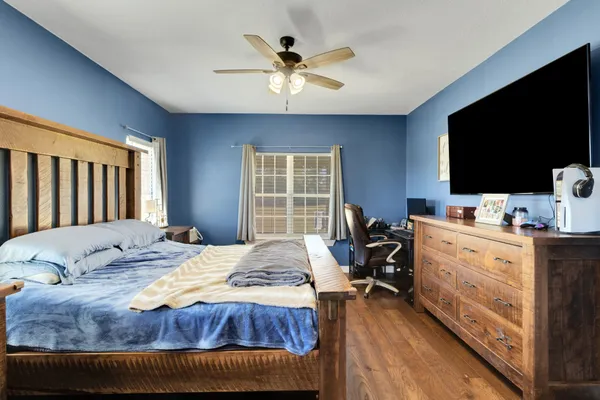 a bed sitting in a bedroom next to a window with pc on the floor