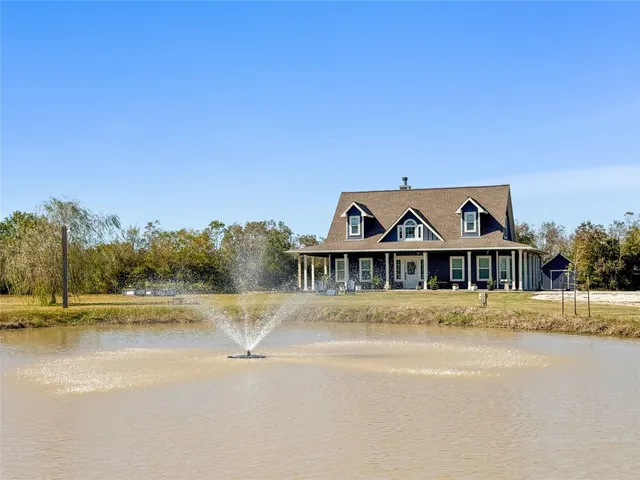 a view of a large house with a yard and lake view