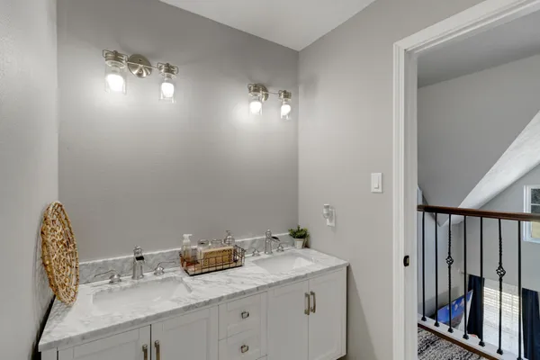a bathroom with a granite countertop sink a light fixture and a mirror