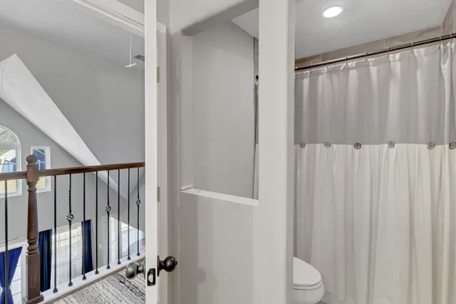 a bathroom with a shower curtain and toilet