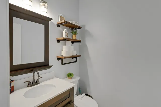 a bathroom with a sink vanity mirror and toilet