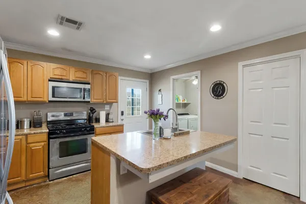 a kitchen with stainless steel appliances granite countertop a stove a sink and a refrigerator