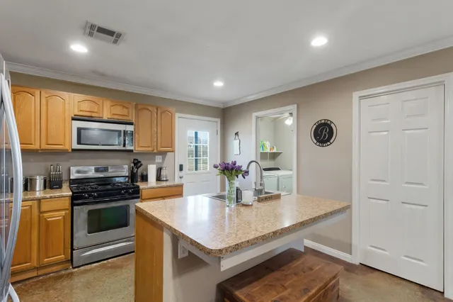 a kitchen with stainless steel appliances granite countertop a stove a sink and a refrigerator