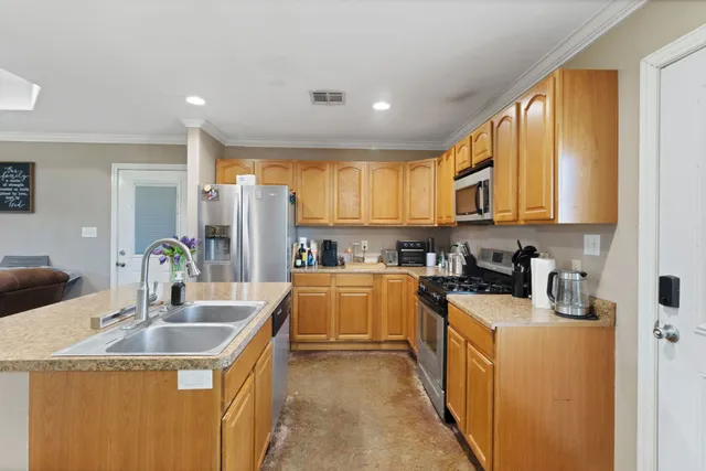 a kitchen with stainless steel appliances granite countertop a sink a stove and a refrigerator