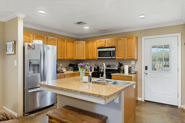 a kitchen with stainless steel appliances granite countertop a refrigerator a stove top oven a sink and dishwasher