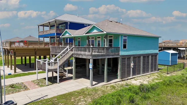 a view of house with a yard and balcony