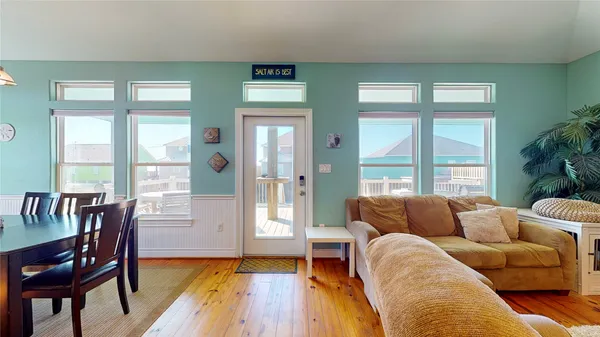 a living room with furniture and two large window