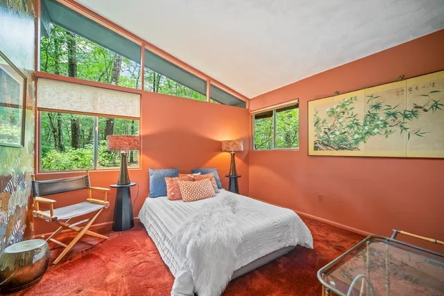 a bedroom with a bed and glass windows