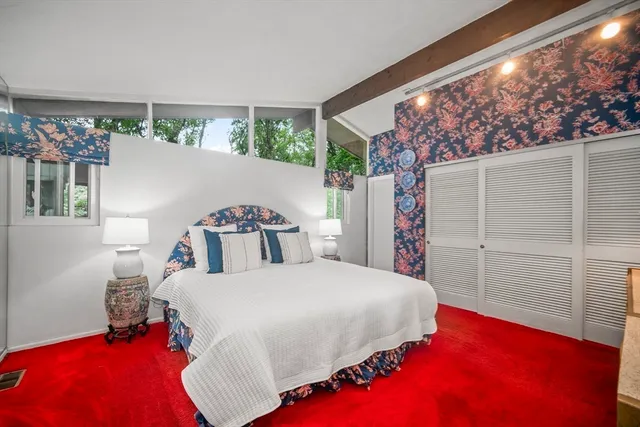 a bedroom with a large bed and a window