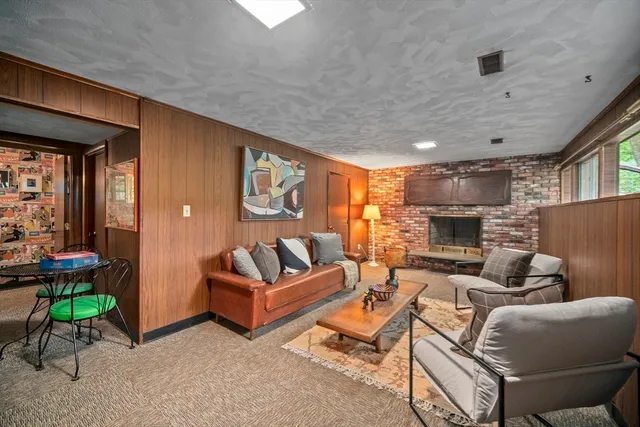 a living room with fireplace furniture and a large window