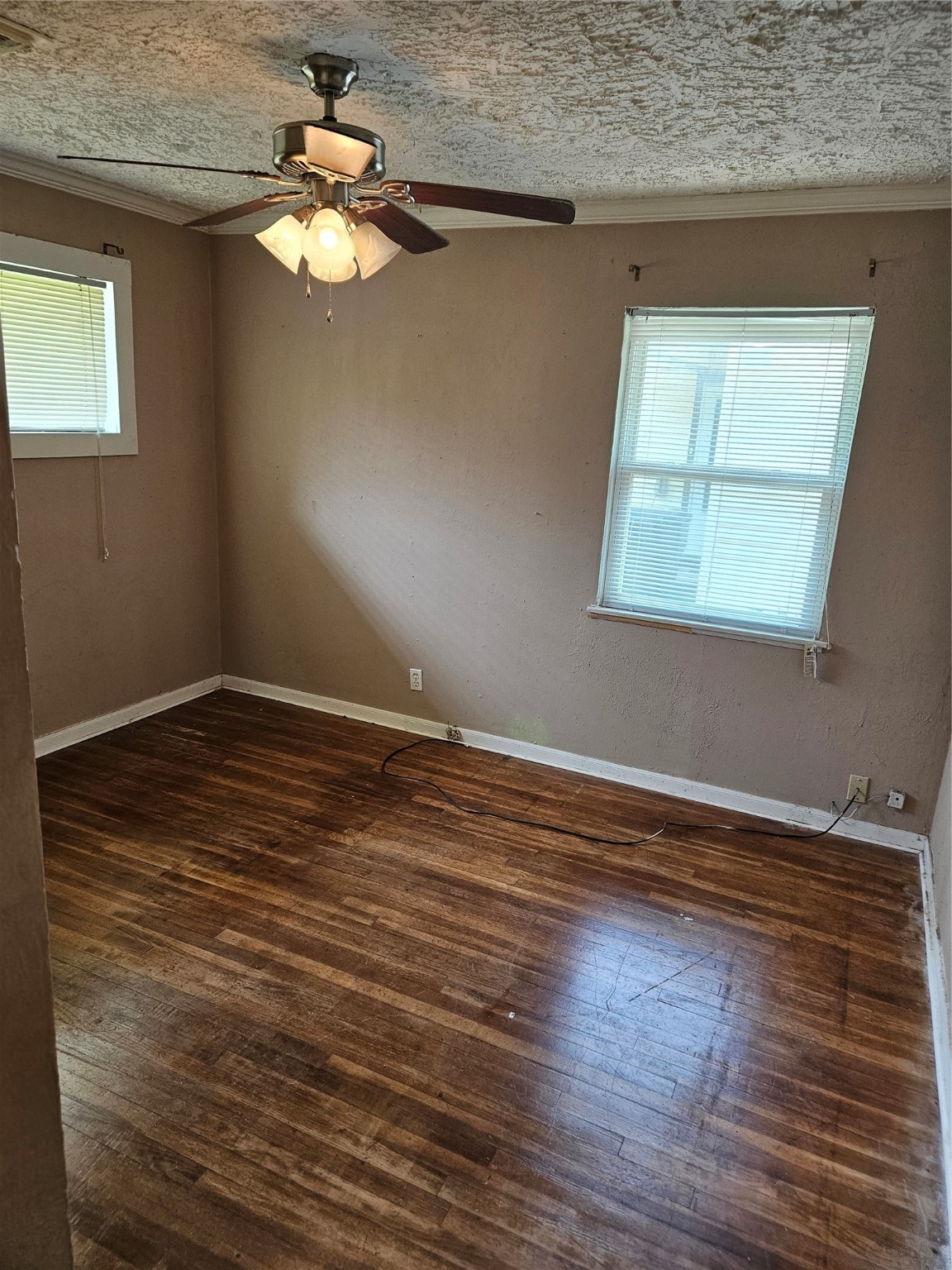 5218 Cortelyou Lane Houston, TX 77021 - Photo 20 of 45 an empty room with wooden floor chandelier fan and windows