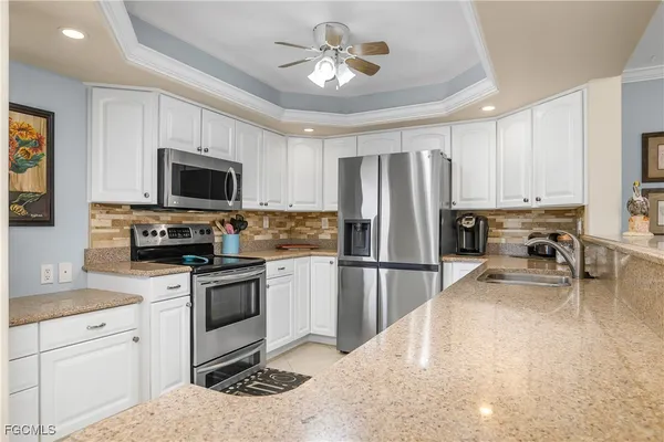 a kitchen with kitchen island a refrigerator stove microwave and cabinets