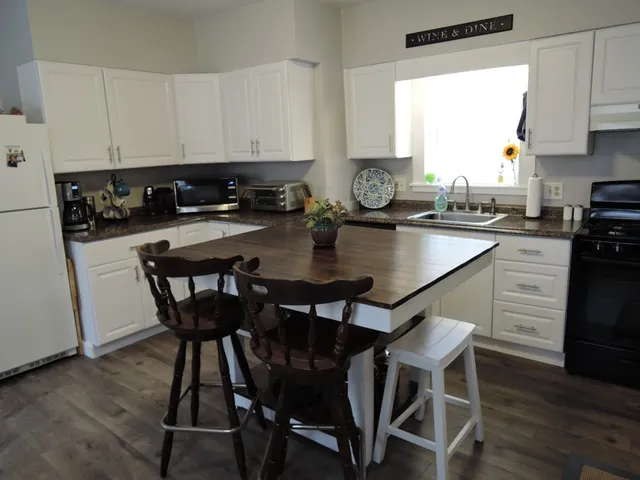 a kitchen with a dining table chairs and cabinets