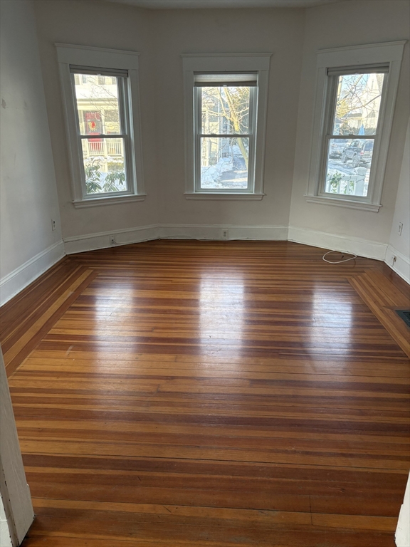 9 Maple Street Watertown, MA 02472 - Photo 3 of 11 an empty room with wooden floor and windows
