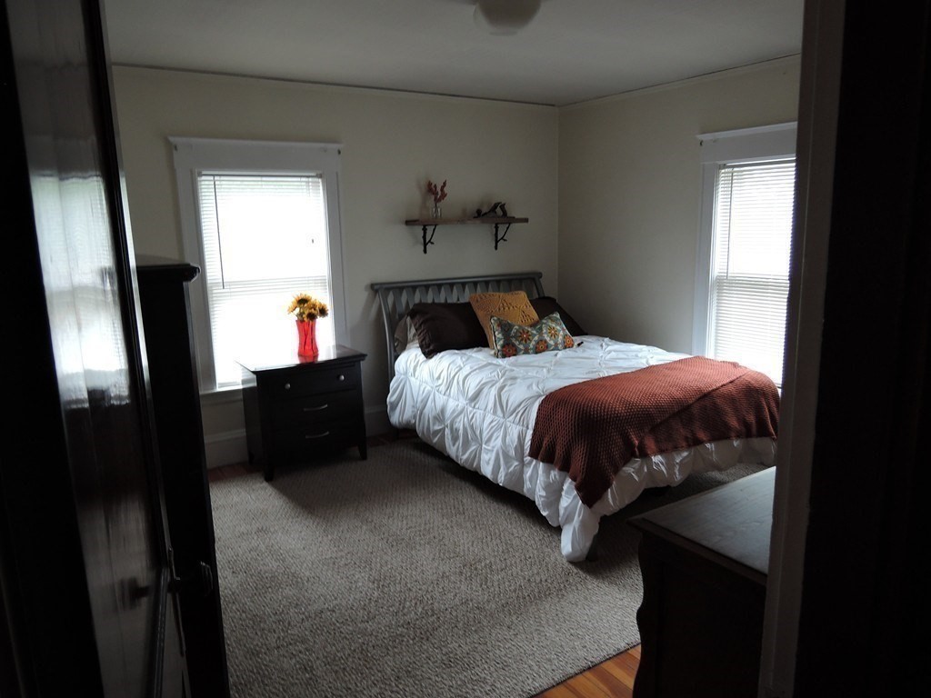 9 Maple Street Watertown, MA 02472 - Photo 8 of 11 a bedroom with a bed and wooden floor