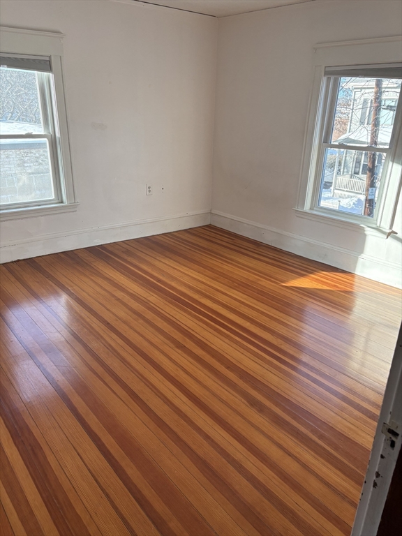 9 Maple Street Watertown, MA 02472 - Photo 9 of 11 an empty room with wooden floor and windows