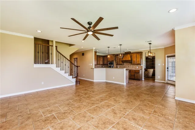 a view of an empty room with a window and a ceiling fan
