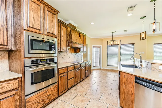 a kitchen with stainless steel appliances granite countertop a stove a sink and a microwave